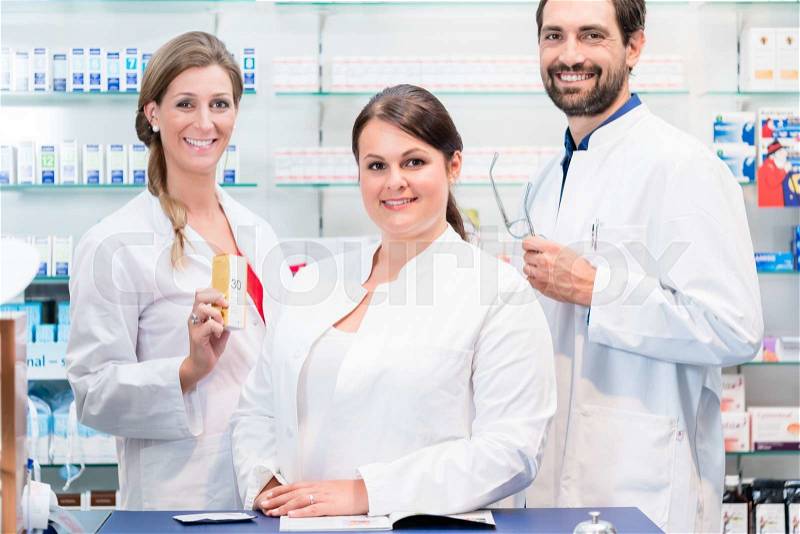 Team of pharmacists in drug store checking pharmaceuticals, stock photo