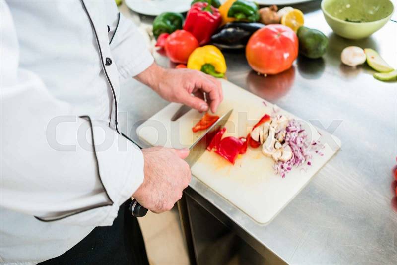 Chef cutting onions and vegetable to prepare for cooking, stock photo