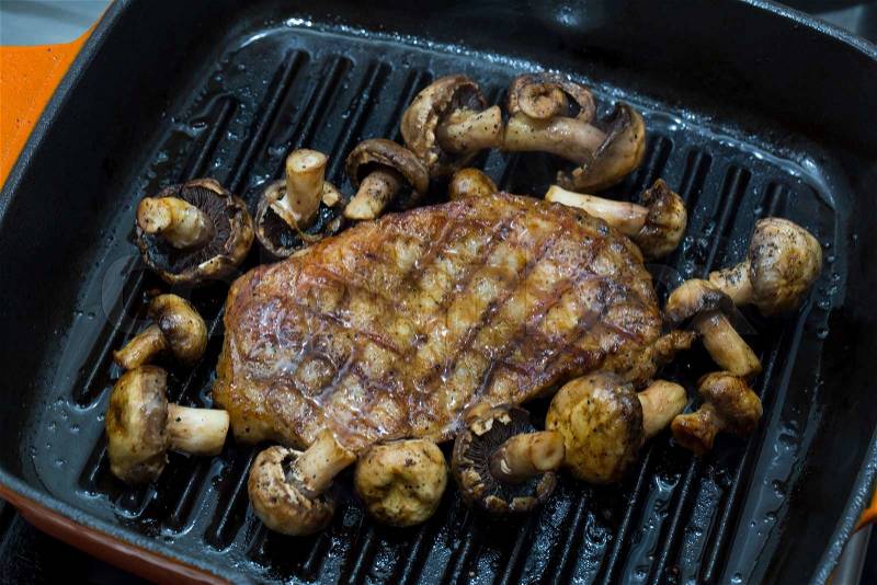Cooking steak and mushrooms on the grill pan, stock photo