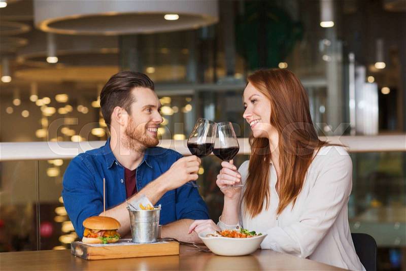Leisure, celebration, food and drinks, people and holidays concept - smiling couple having dinner and drinking red wine at date in restaurant, stock photo