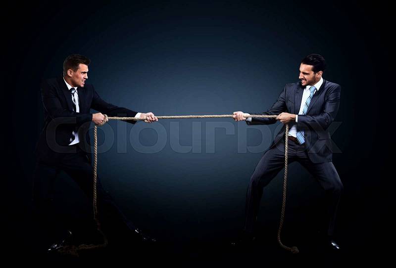 Two business men pulling rope in a competition. on dark background, stock photo