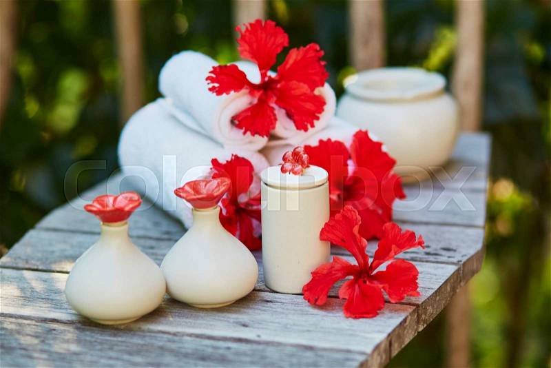 Spa setting with towels and beautiful red hibiscus flowers, stock photo