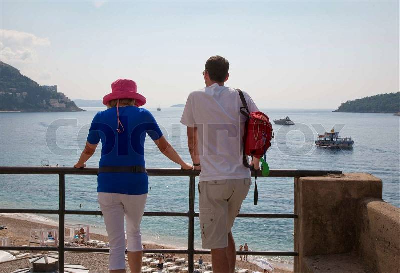 Happy young couple enjoying the view of the Adriatic Sea and the beach of Dubrovnik, Croatia at summertime, stock photo