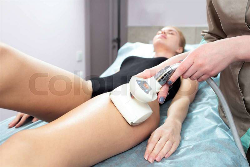 Young woman in the beauty services, body shaping. Masseur makes vacuum roller massage for client. Figure correction and anti cellulite massage in the professional beauty clinic, stock photo