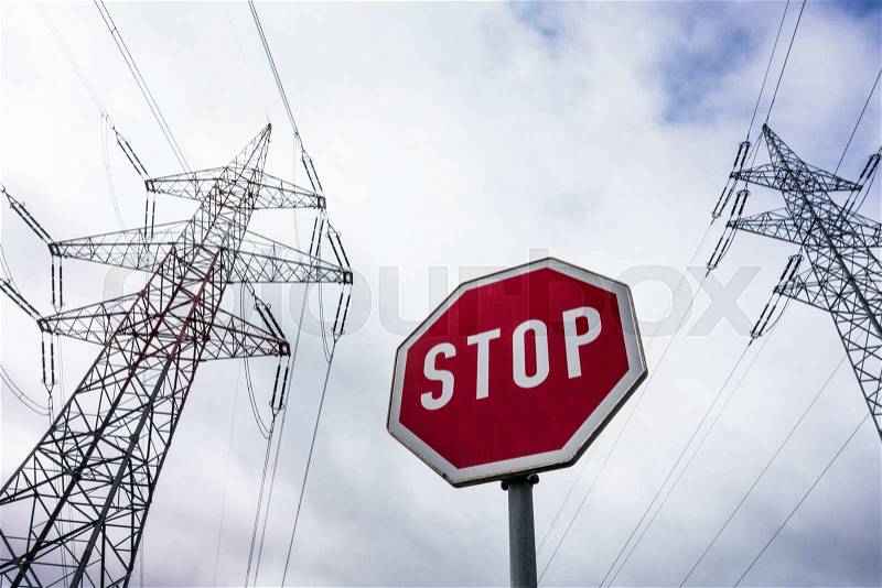 A pole of a power line and a stop sign. symbol photo for phasing out nuclear power, stock photo