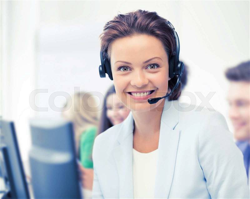 Business and call center concept - helpline operator with headphones in call centre, stock photo