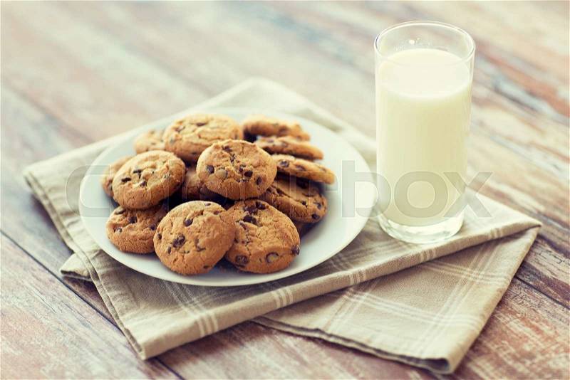 Food, junk-food, culinary, baking and eating concept - close up of chocolate oatmeal cookies and milk glass on plate, stock photo