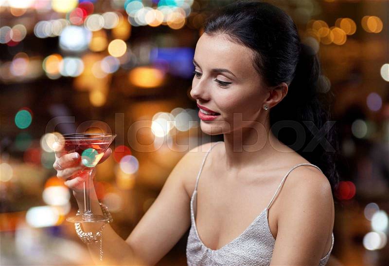 People, party, nightlife, drink and holidays concept - glamorous woman with cocktail at night club or bar, stock photo