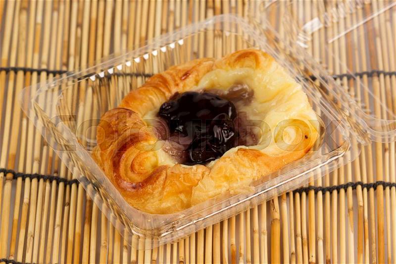 Danish pastry with blueberries jam on plastic box, stock photo