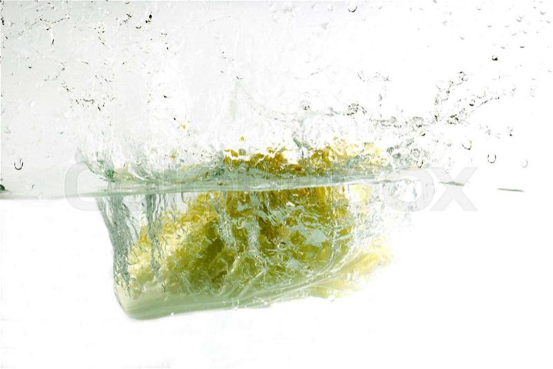 Cabbage falling in water on blue with air bubbles , stock photo