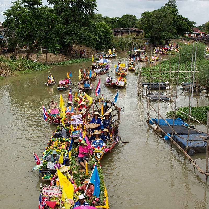 AYUTTHAYA, THAILAND - JULY 11: Unidentified people on flower boats in floating parade, the unique annual candle festival of Buddhist lent on July 11, 2014 in Ladchado, Ayutthaya, Thailand, stock photo