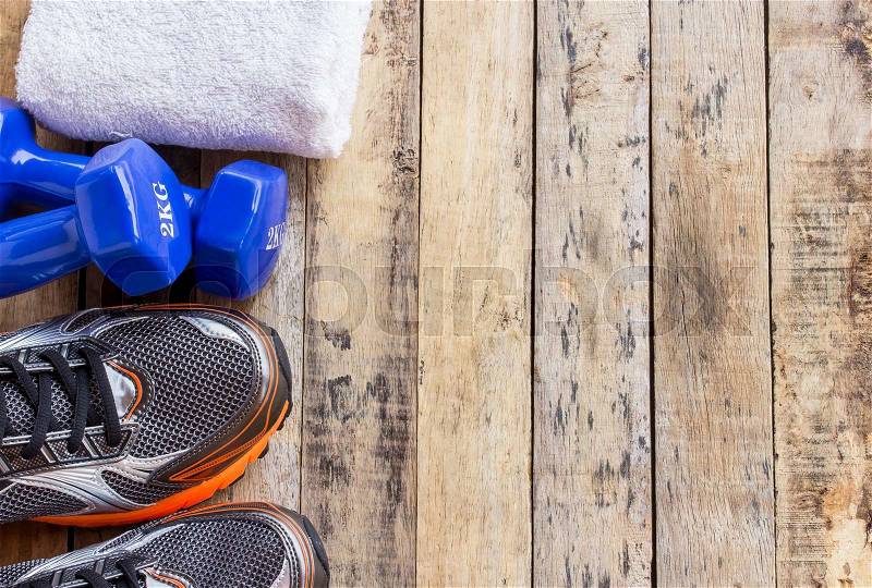 Blue dumbbells,towel and sports shoes on wooden table. Fitness concept, stock photo