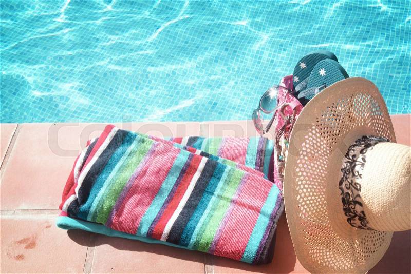 Towel and bathing accessories near pool side, retro toned, stock photo