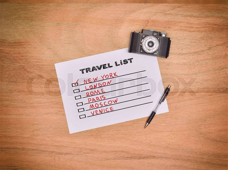 Vintage camera, pen and drawing travel list on paper, stock photo