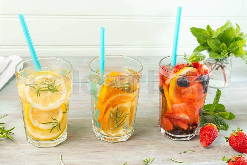 Detox water cocktails on wooden table, stock photo