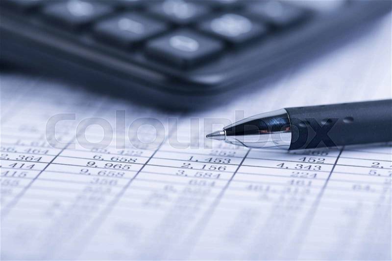 A calculator and a ball pen is on a balance sheet. Concept for sales, profit and cost, stock photo