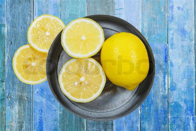 Sliced lemons isolated on blue wood background, stock photo