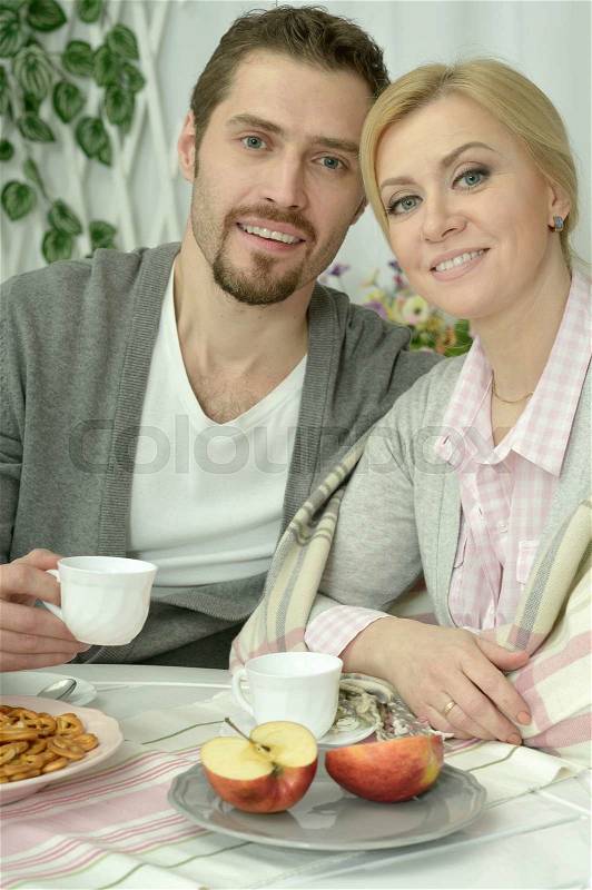 Smiling couple at table with coffee and food, stock photo