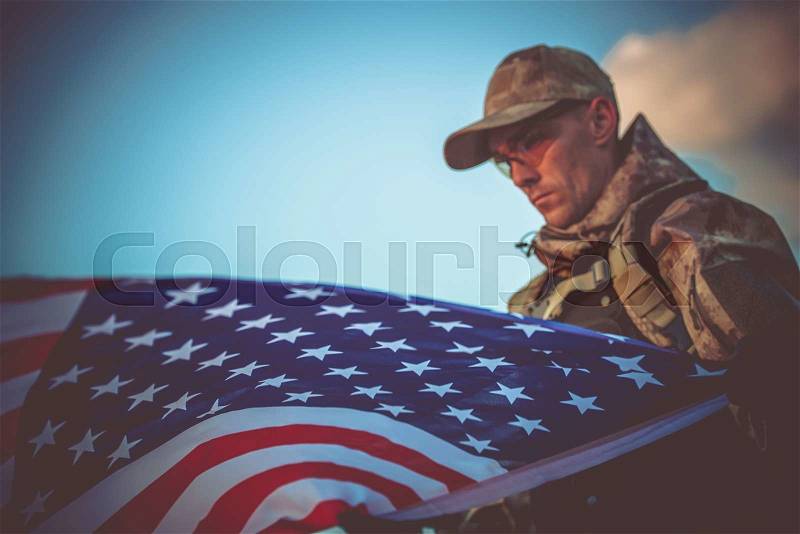 Young Army Veteran with American Flag Closeup Photo. Army Trooper with USA Flag, stock photo