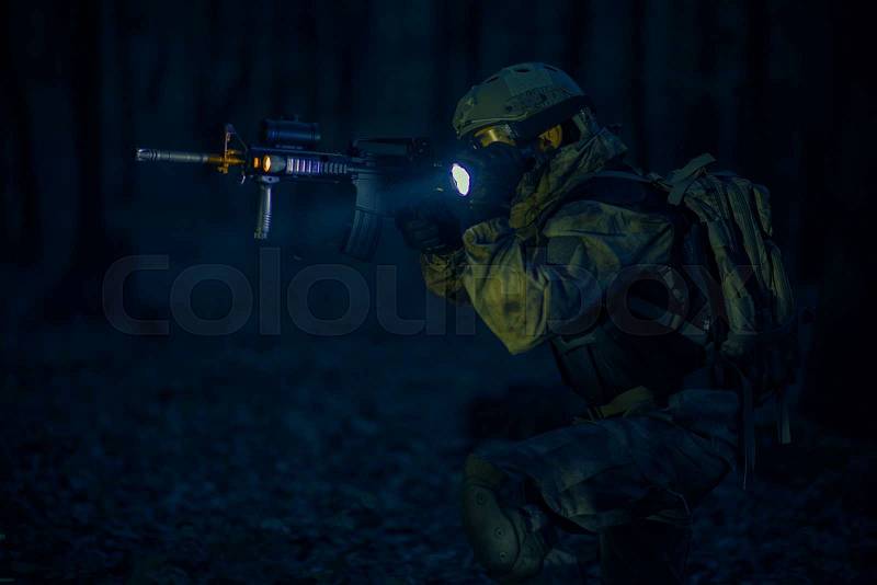 Military Night Operation. Soldier with Assault Rifle and Flashlights at Night, stock photo