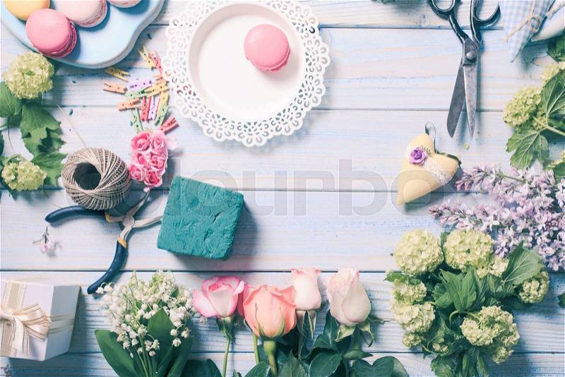 Preparation of flower box with macaroons, top view of florist workplace, stock photo