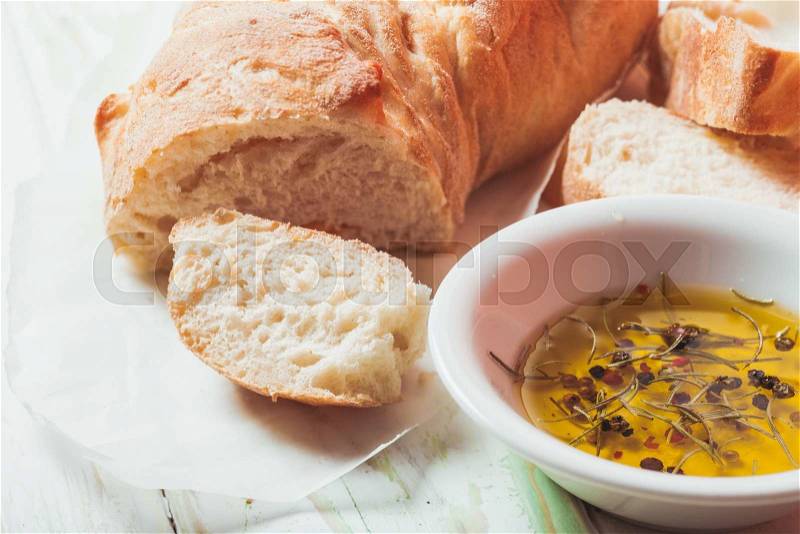 Ciabatta - italian bread with olive oil and spices over wooden table, stock photo