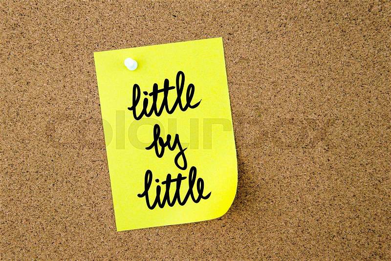 Little By Little written on yellow paper note pinned on cork board with white thumbtacks, copy space available, stock photo