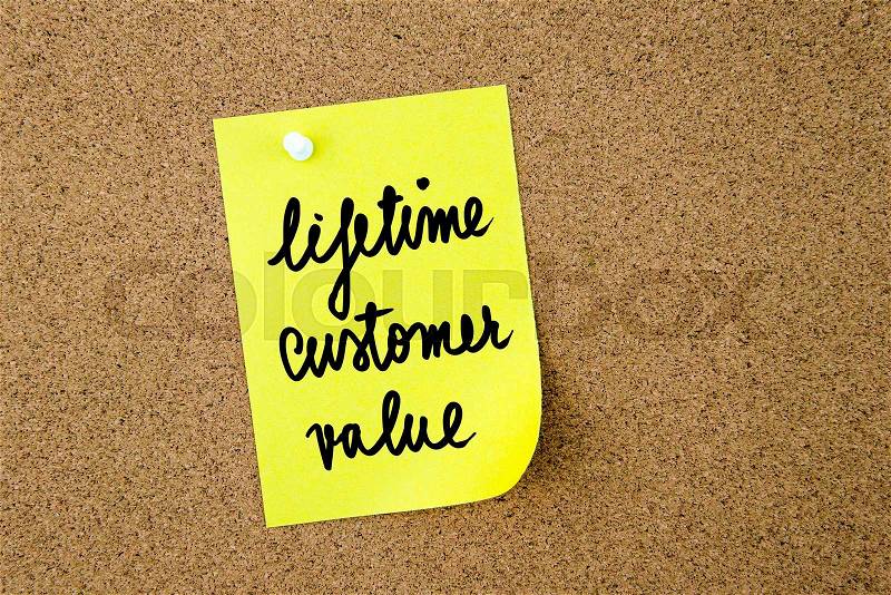 Lifetime Customer Value written on yellow paper note pinned on cork board with white thumbtacks, copy space available, stock photo