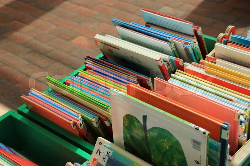 The children books are standing at eye level for the kids at the municipal library in the residential area in the city, stock photo