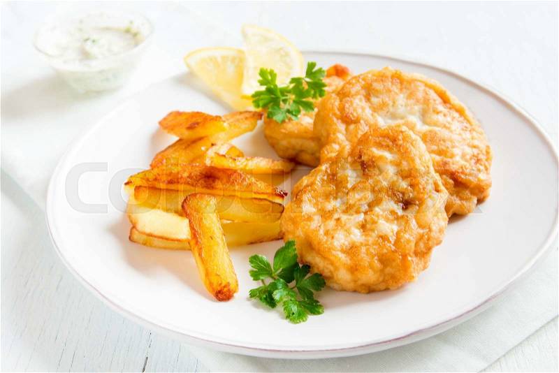Homemade fish cakes with french fries on white plate close up, stock photo