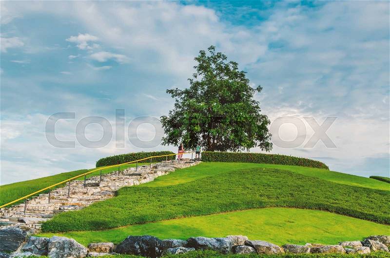 Green little planet with grass on its surface , the man and women stay to alone tree Artificial grass added around the surface of planet. Vintage style, stock photo