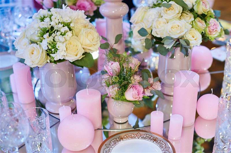 Table set for wedding reception with candles and flower bouquets, stock photo