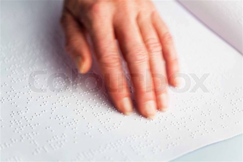 Fingers and Braille. Blind people read a book in Braille, stock photo