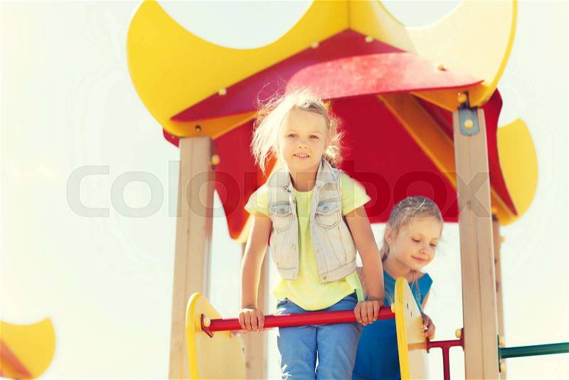 Summer, childhood, leisure, friendship and people concept - happy kids on children playground climbing frame, stock photo