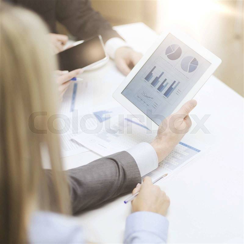 Business and office concept - close up of business team with graph on tablet pc screen and coffee in office, stock photo