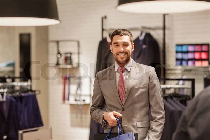 Sale, fashion, retail, business style and people concept - happy man with shopping bags at clothing store, stock photo