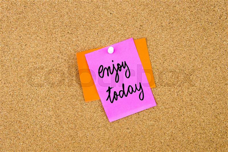 Enjoy Today written on paper note pinned on cork board with white thumbtack, copy space available, stock photo