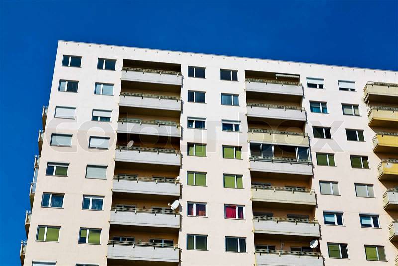 A high-rise building as a residence with balconies in a city, stock photo