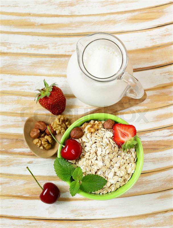Oatmeal, milk, berries and nuts for healthy food, stock photo