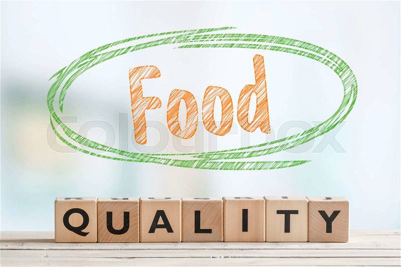 Food quality sign made of wooden cubes on a table, stock photo