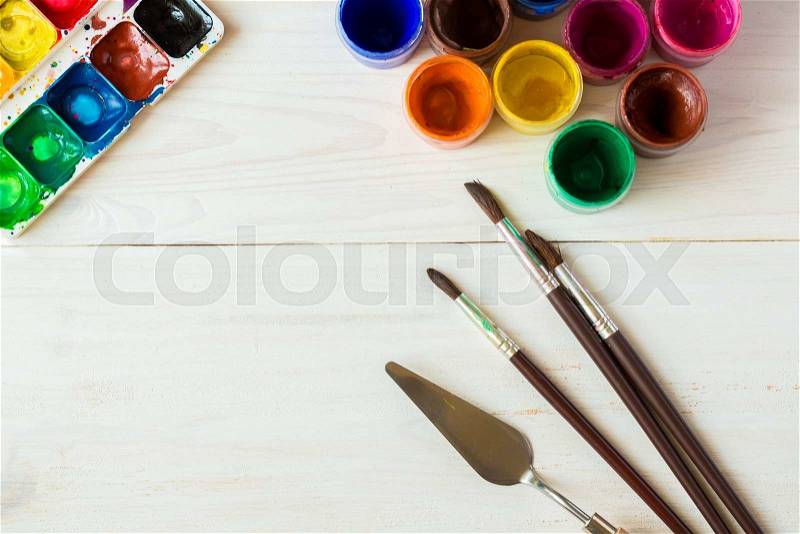 Art of Painting. Painting set: brushes, paints, watercolor, acrylic paint on a white wooden background top down view, stock photo