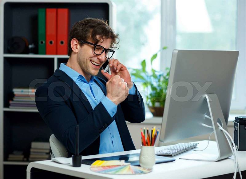 Handsome young man working from home office and using smartphone - modern business concept, stock photo