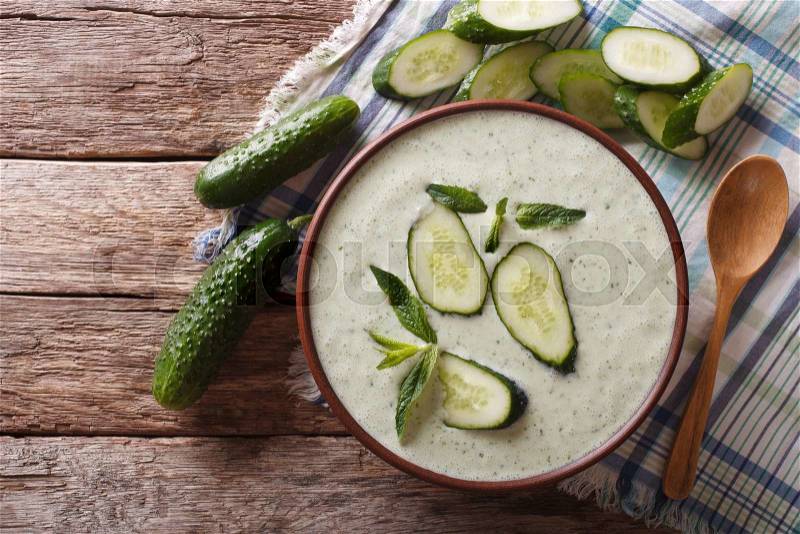Cold cucumber soup with mint and yogurt in a bowl close-up. horizontal view from above , stock photo
