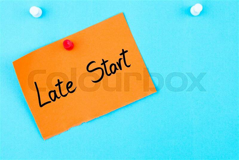 Late Start written on orange paper note pinned on cork board with white thumbtack, copy space available, stock photo