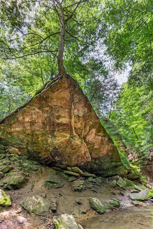 The Wedge Rock rests at what seems to be a precariousl angle in the rugged woodlands of Turkey Run State Park, Indiana, stock photo