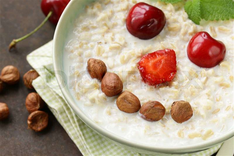 Oatmeal porridge with milk and berries - healthy, funny breakfast, stock photo