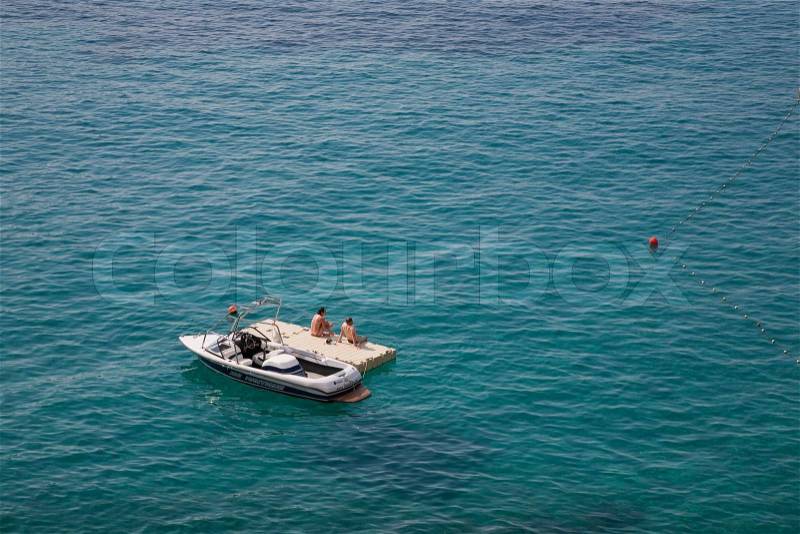 Couple with speedboat on raft in the Adriatic Sea, Croatia. Space for text, stock photo