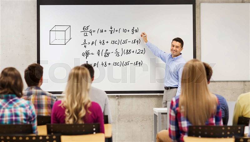 Education, high school, mathematics and people concept - smiling teacher standing in front of students and writing mathematical equalities on white board in classroom, stock photo