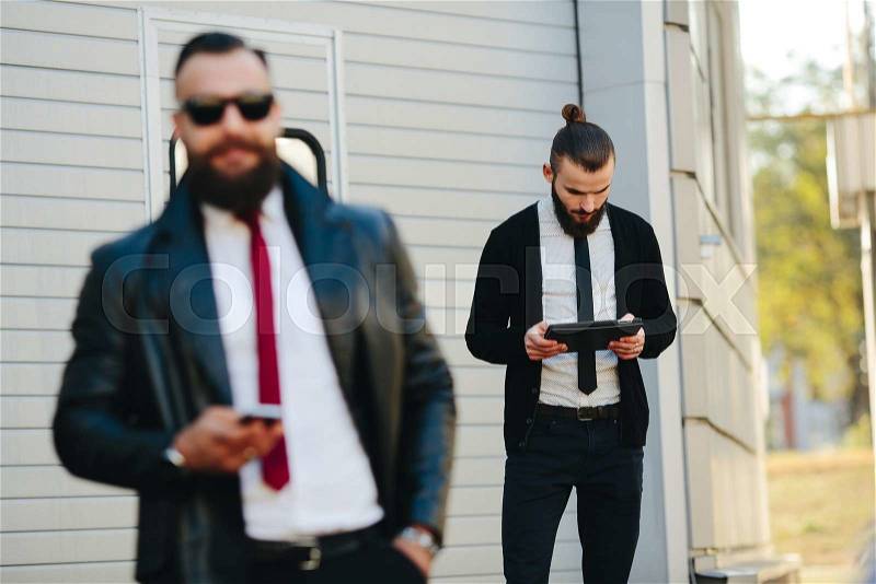 Two bearded businessman working on the street, stock photo