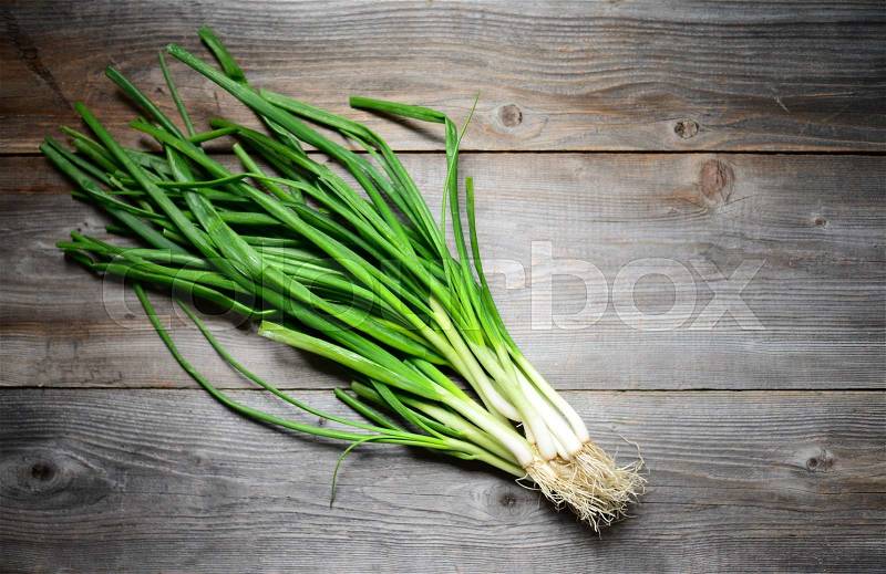Fresh spring onion on wooden background, stock photo